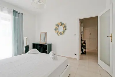 a white bedroom with a bed and a clock on the wall at White Boutique Apartment in Rome