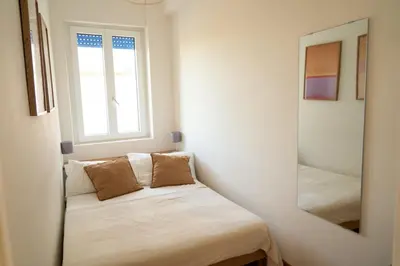 a small bedroom with a bed and a mirror at Cozy Pigneto Flat with Balcony in Rome