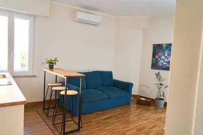 a living room with a blue couch and a table at Cozy Pigneto Flat with Balcony in Rome