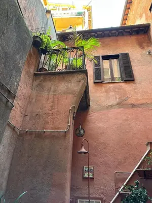 a building with a balcony with plants on it at Arco Acetari - The Middle Ages in the heart of Rome in Rome