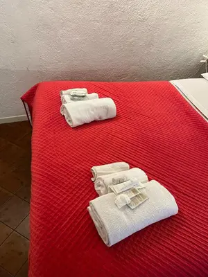 a red bed with towels on top of it at Arco Acetari - The Middle Ages in the heart of Rome in Rome