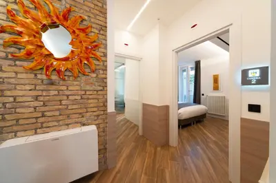 a living room with a brick wall and a mirror at Chessa's Rooms in Rome