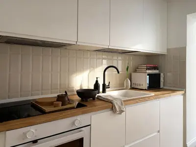 a kitchen with white cabinets and a sink at Monti Mood Design Apt - via Urbana - BRAND NEW in Rome