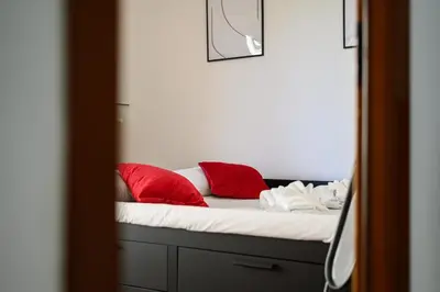 a bed with red pillows on it in a room at NEW Diana's place with terrace San Pietro Station in Rome