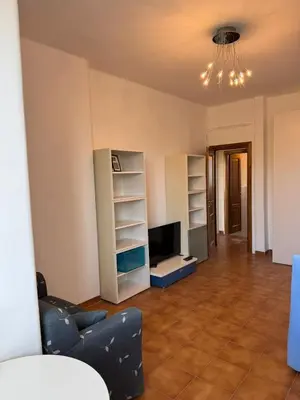 a living room with a couch and a tv and shelves at House - Furio Camillo - Too in Rome