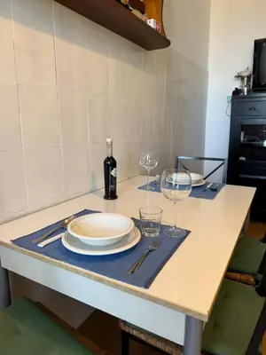 a table with a plate and wine glasses on it at House - Furio Camillo - Too in Rome