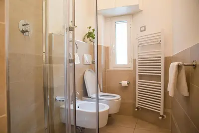 a bathroom with a toilet and a glass shower at Chat&Chill Vatican Apartment in Rome