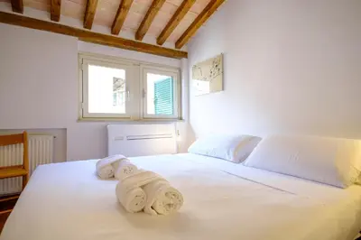 a bedroom with a large white bed with towels on it at Elegantis Monti Penthouse With Private Terrace and Colosseum View in Rome