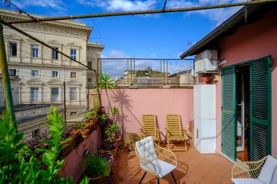 a balcony with chairs and a building at Elegantis Monti Penthouse With Private Terrace and Colosseum View in Rome