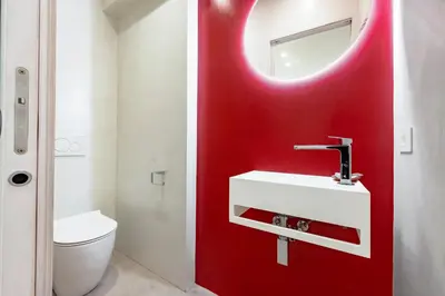 a bathroom with a red wall with a sink and a mirror at Skylife Garden of Olives in Rome
