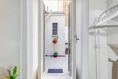a hallway with a door open to a courtyard with plants at Vatican Scipioni Charming Studio relaxing and patio in Rome