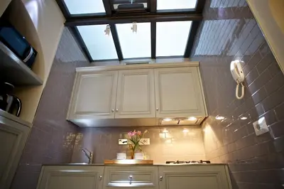 a kitchen with a skylight and a counter with flowers on it at Vatican design loft in Rome
