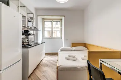 a small room with a bed and a kitchen at Albadoro Apartment in Rome