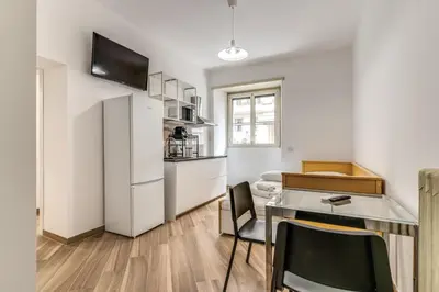 a small kitchen with a table and a refrigerator at Albadoro Apartment in Rome