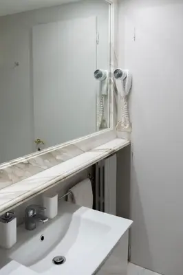 a bathroom with a sink and a large mirror at Caesarina Roma, Luxury apartment in Rome