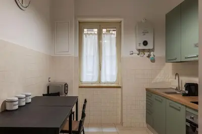 a kitchen with a table and a window in it at GuestHost - Trastevere Apartment Roma Portuense in Rome