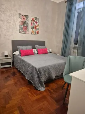a bedroom with a bed with two red pillows at Aurelio Vatican Holiday in Rome