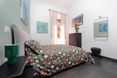 a bedroom with a bed with a floral bedspread at Neo Urbis Art Aparts in Rome