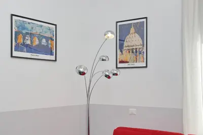 a floor lamp in a room with two pictures on the wall at Neo Urbis Art Aparts in Rome