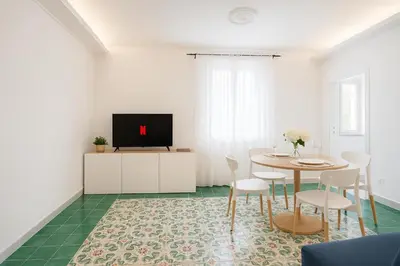 a white living room with a table and a tv at Cola di Rienzo Attico & Charme - by 101 Flats in Rome