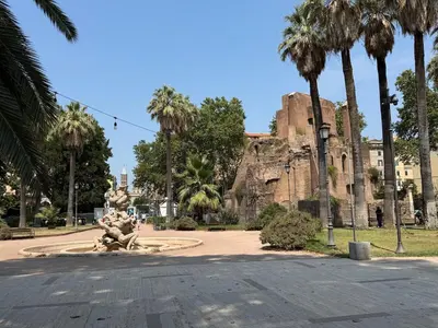 a park with palm trees and a fountain in front of a castle at Casa di Mara by Valentina's Dream in Rome