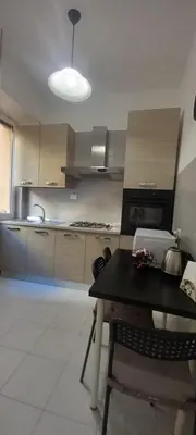 a kitchen with a table and a kitchen with a stove at Alessandro's Home in Rome