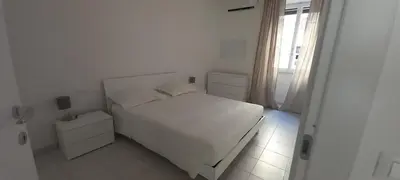 a white bedroom with a white bed and a window at Alessandro's Home in Rome