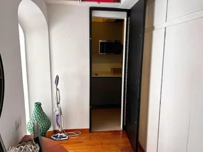 a hallway with a door into a kitchen with a microwave at Stay by the Pantheon in the Heart of Historic Rome in Rome