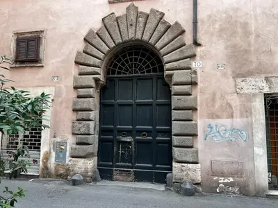 a large black door in the side of a building at Stay by the Pantheon in the Heart of Historic Rome in Rome