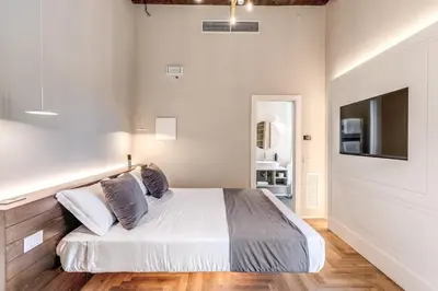 a white bedroom with a bed and a television at AGH Pantheon in Rome