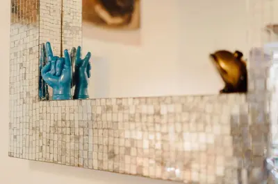 a tiled wall with two blue gloves on a shelf at The Oasis of Trastevere in Rome