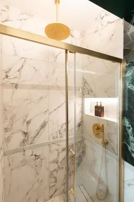 a bathroom with a shower with white marble walls at Lary's - San Pietro in Rome