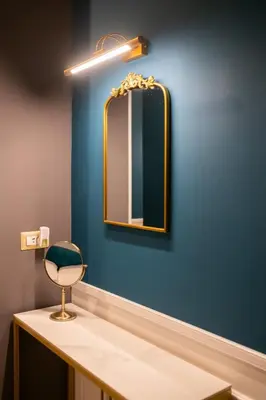 a bathroom with a mirror on a blue wall at Lary's - San Pietro in Rome