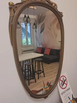 a mirror in a living room with a table and a couch at Trastevere St Rolli 15 in Rome