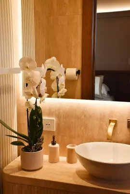 a bathroom with a sink and a vase with white flowers at Spanish Steps - Luma Suite - Terraces & Rome View in Rome