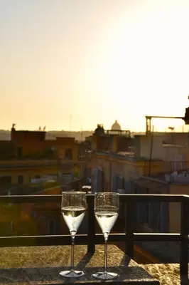 two glasses of white wine sitting on a balcony at Spanish Steps - Luma Suite - Terraces & Rome View in Rome