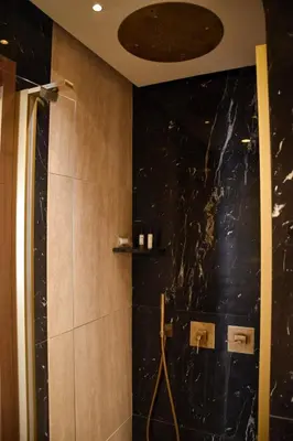 a bathroom with a shower with a black marble wall at Spanish Steps - Luma Suite - Terraces & Rome View in Rome