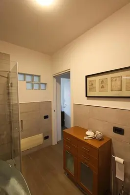 a bathroom with a shower and a wooden table at Clio Apartment in Rome