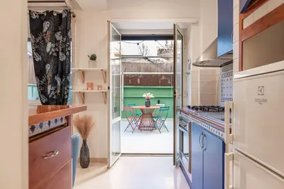 a kitchen with a door leading to a table at Vatican Museums Apartment with Romantic Terrace in Rome