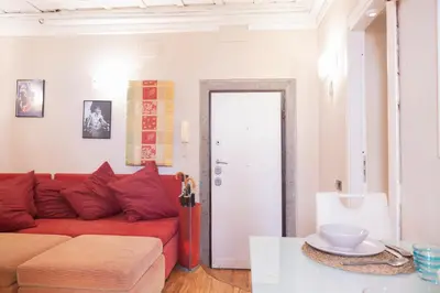 a living room with a red couch and a table at La Dolce Vita Pantheon Suite in Rome