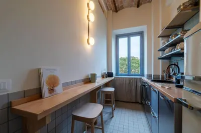 a kitchen with a counter with two stools in it at GuestHost - Elegant Apartment Testaccio Roma in Rome