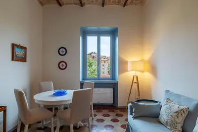 a living room with a table and a blue couch at GuestHost - Elegant Apartment Testaccio Roma in Rome