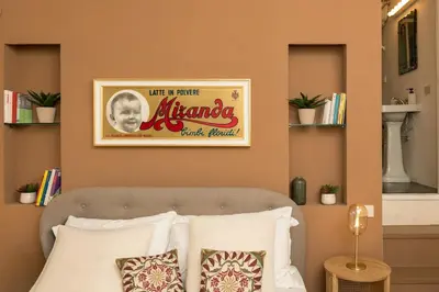 a bedroom with a picture above a bed with pillows at Lungaretta Trastevere Penthouse Mimì & Cocò Home in Rome