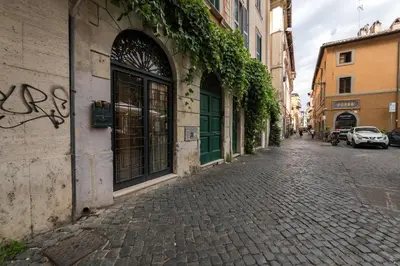 a cobblestone street with ivy on the side of a building at Lungaretta Trastevere Penthouse Mimì & Cocò Home in Rome
