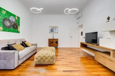 a living room with a couch and a tv at Luxury Ludo House Trastevere in Rome