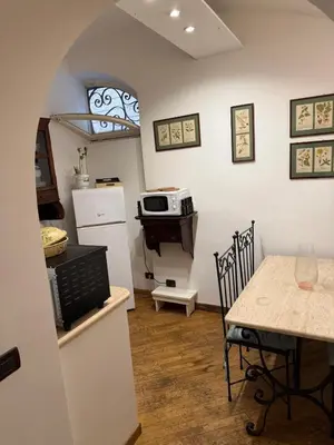a kitchen and dining room with a table and a microwave at La casetta nel vicolo in Rome