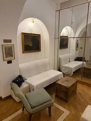 a room with two beds and a chair and a table at La casetta nel vicolo in Rome