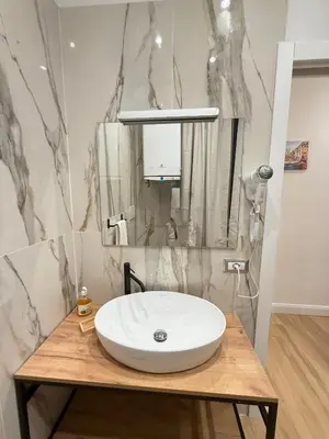 a bathroom with a white sink on a wooden table at NAVONA MORGAN suite in Rome