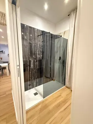 a glass shower in a room with a wooden floor at NAVONA MORGAN suite in Rome