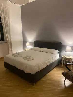 a bedroom with a bed with two lamps and a chair at Residenza Prati in Rome